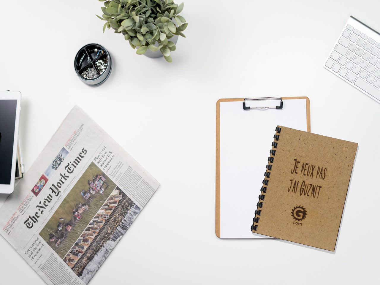 Cahier avec une inscription sur la couverture " Je peux pas j'ai Guzmit " mis en situation sur un bureau